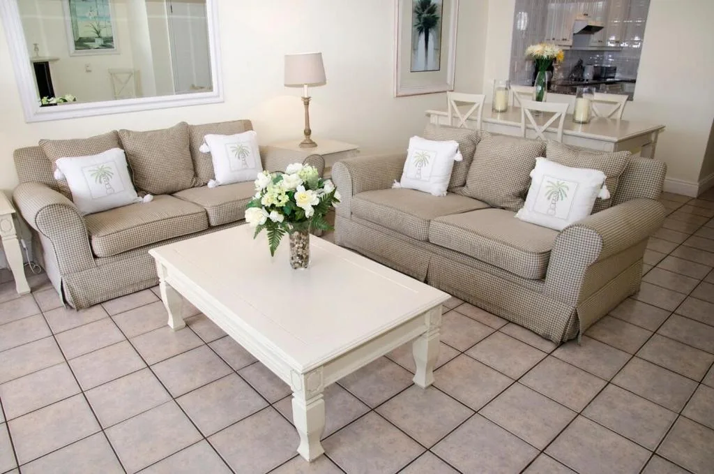 Spacious lounge with beige sofas, white coffee table, fresh flowers
