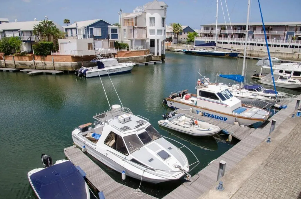 Waterfront lagoon with moored boats and colorful residential buildings