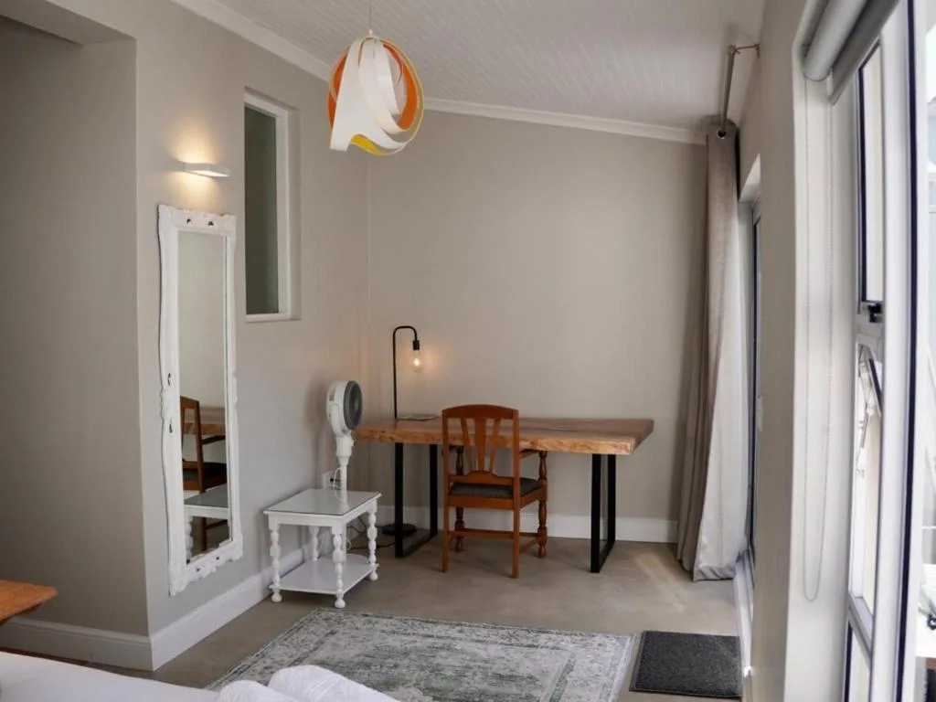 Modern bedroom workspace with wooden desk, chair, and pendant lighting fixture
