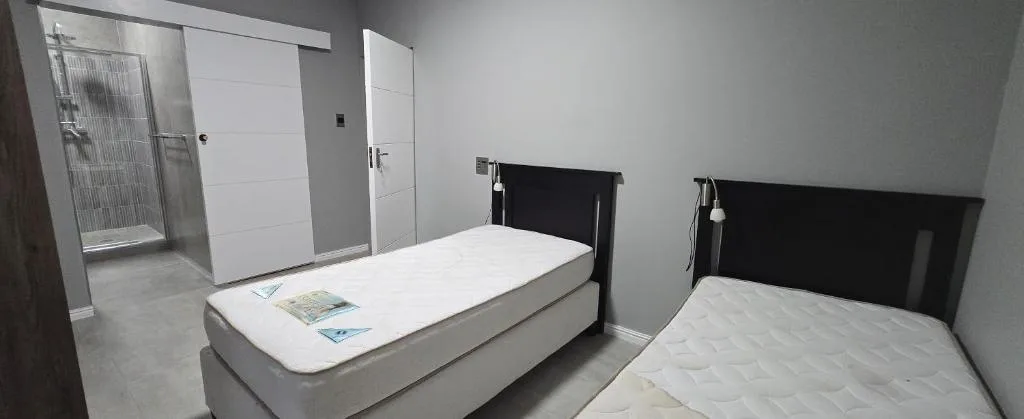 Modern bedroom with two single beds and contemporary black headboards