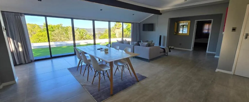 Modern dining table with chairs overlooking garden and lagoon views