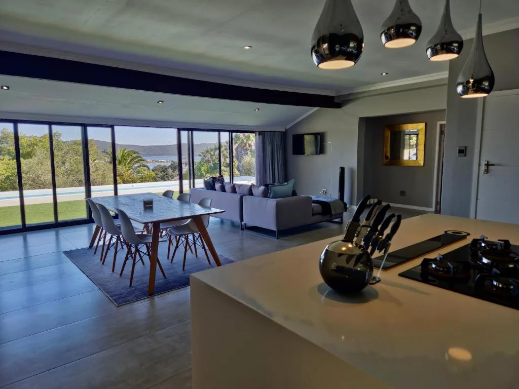 Modern open-plan lounge with dining area and mountain views through floor-to-ceiling windows