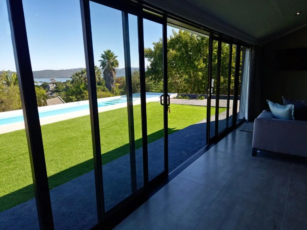 Modern lounge with floor-to-ceiling windows overlooking pool and lagoon