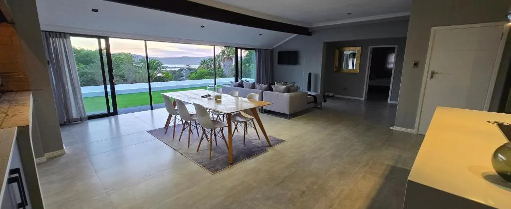 Open-plan lounge and dining area with pool and lagoon views
