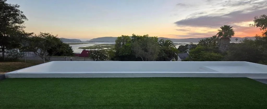 Lagoon and mountain sunset view from garden deck area at dusk