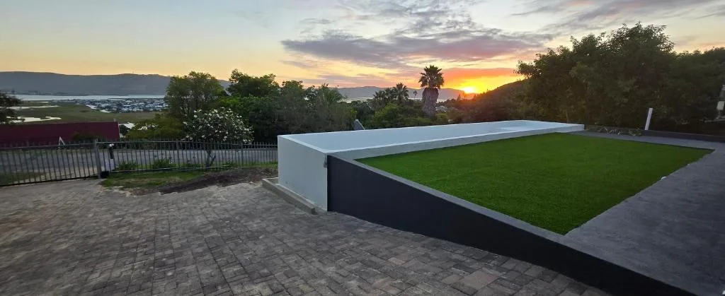 Sunset over Knysna Lagoon from property with manicured garden and deck