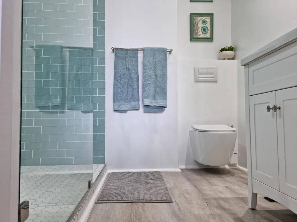 Modern bathroom with walk-in shower, toilet, and vanity cabinet