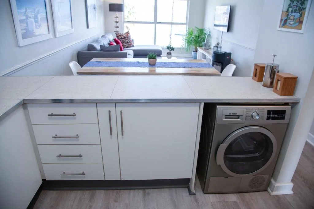 Modern laundry area with built-in washing machine and white cabinetry