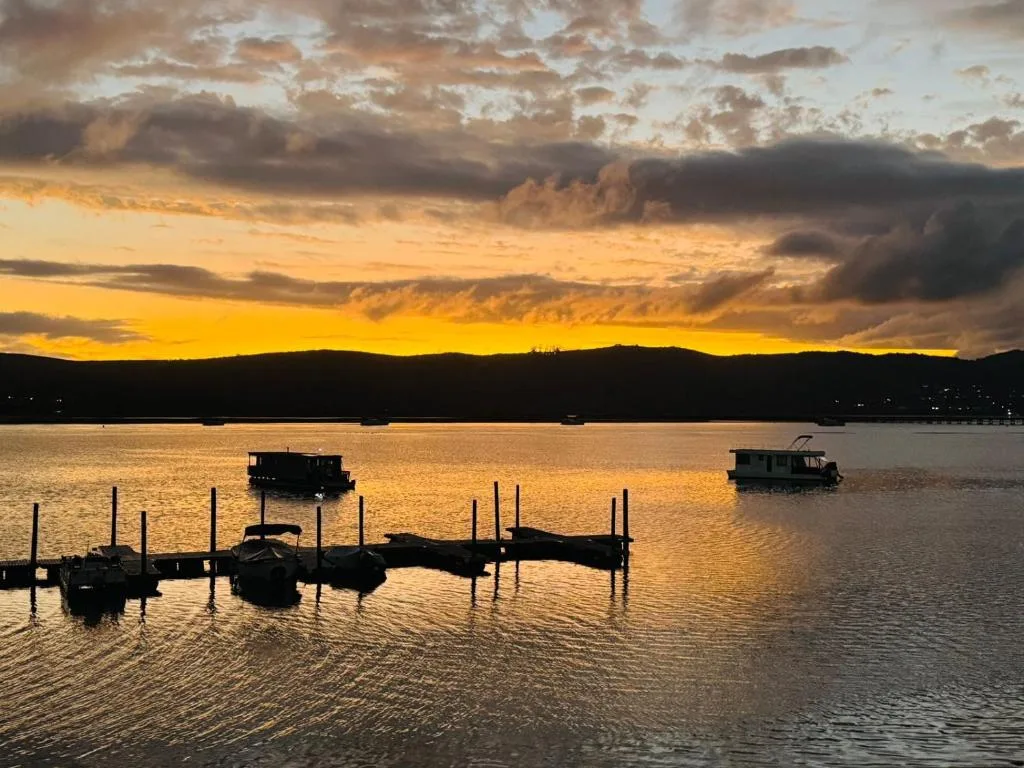 Sunset over Knysna Lagoon with moored boats and mountains silhouetted