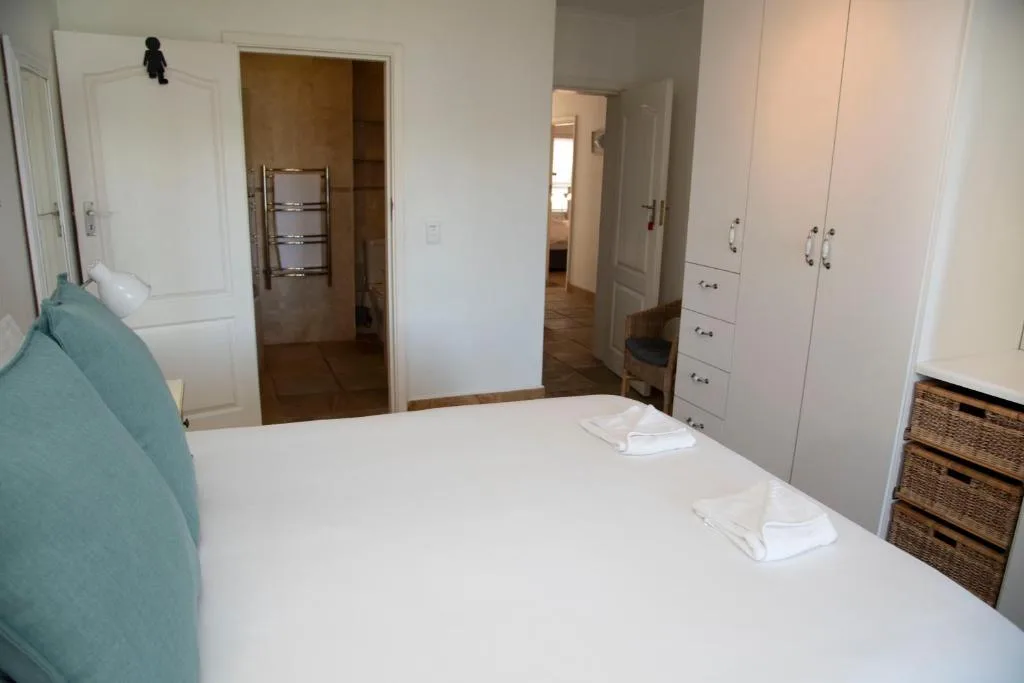 Spacious bedroom with queen bed, built-in wardrobes, and ensuite bathroom access