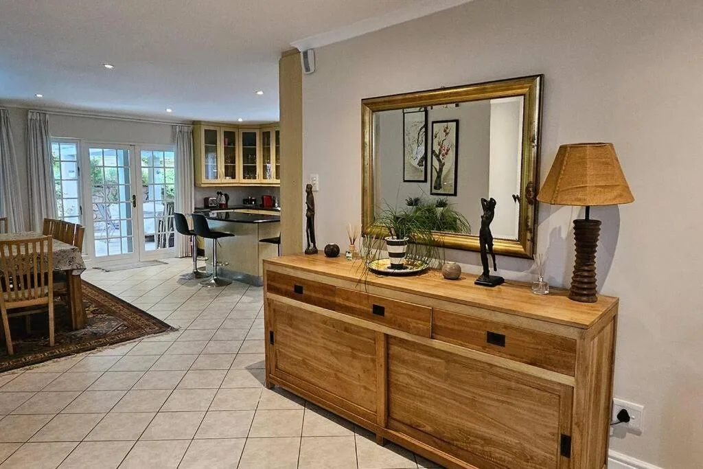 Wooden dresser with mirror and lamp in open-plan living space