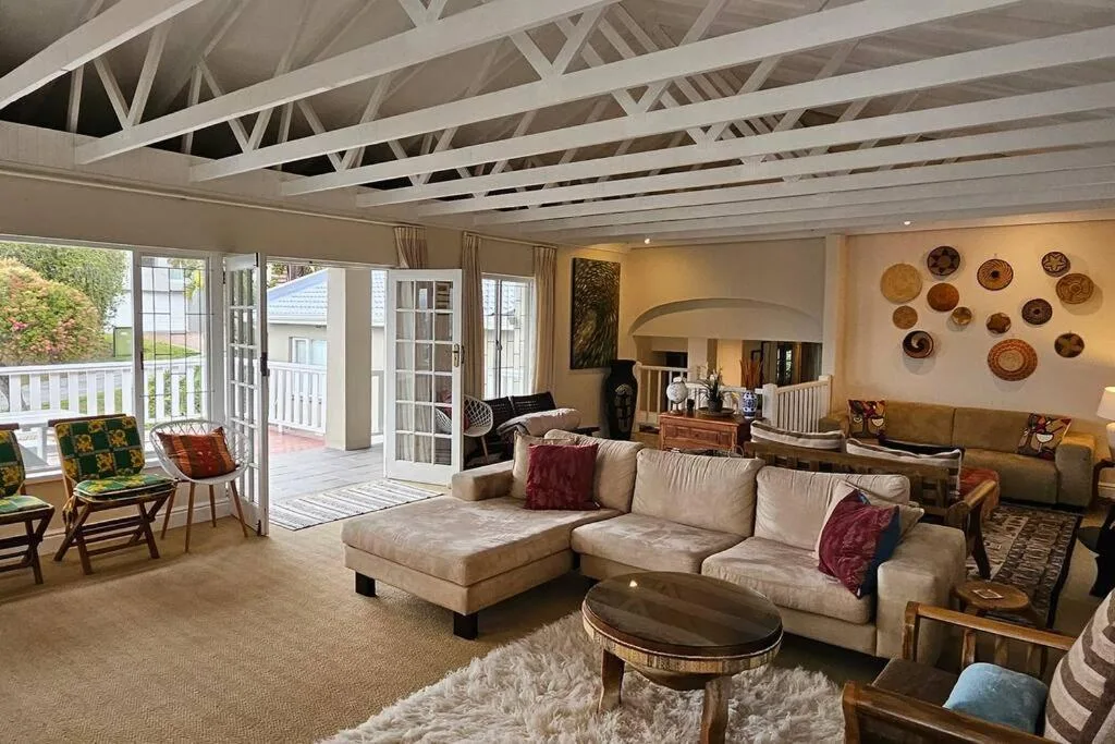 Spacious living room with cream sectional sofa and exposed white ceiling beams