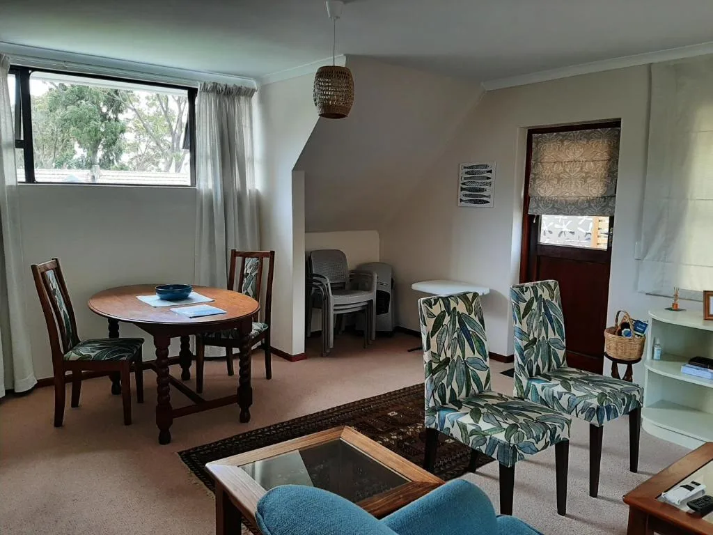 Open lounge area with patterned armchairs, dining table, and natural light