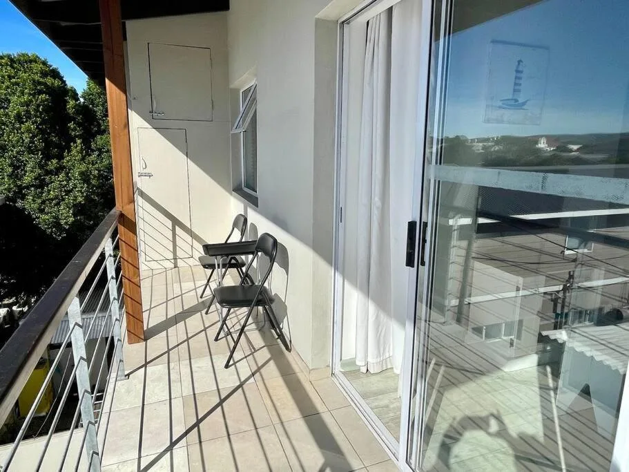 Sunny balcony with seating overlooking lagoon and forested hills