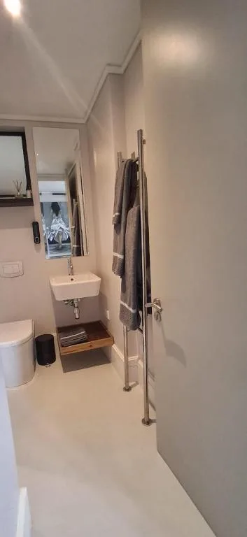 Modern bathroom with white sink, toilet, and heated towel rail