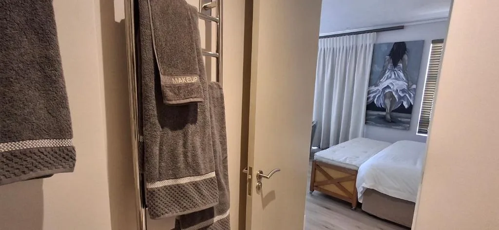 Bathroom with towel rack and designer towels near entrance