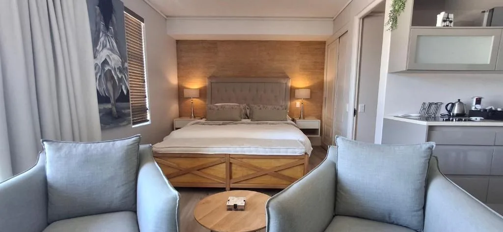 Spacious bedroom with wooden bed frame and warm ambient lighting throughout