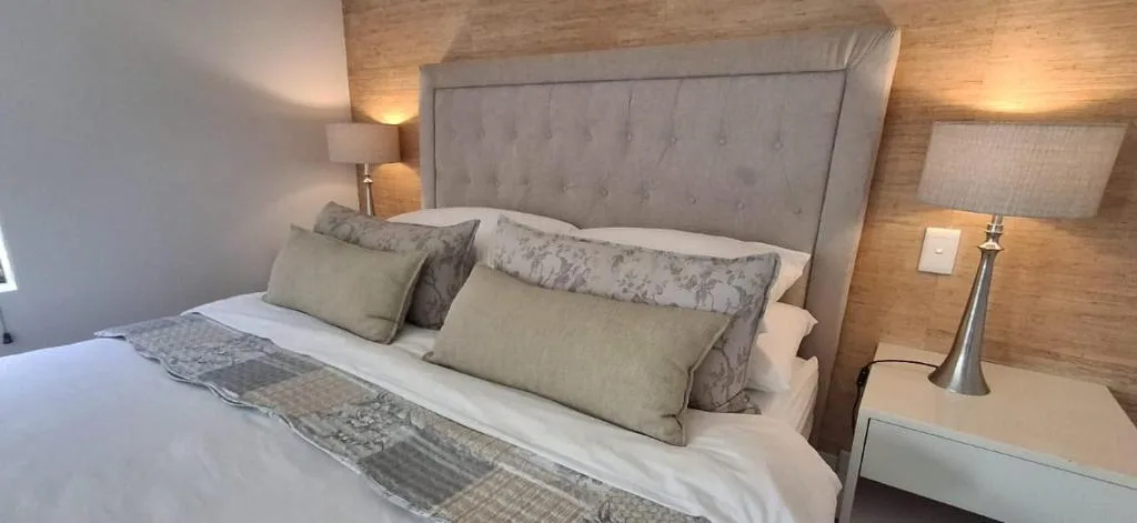 Modern bedroom with upholstered gray headboard and neutral bedding