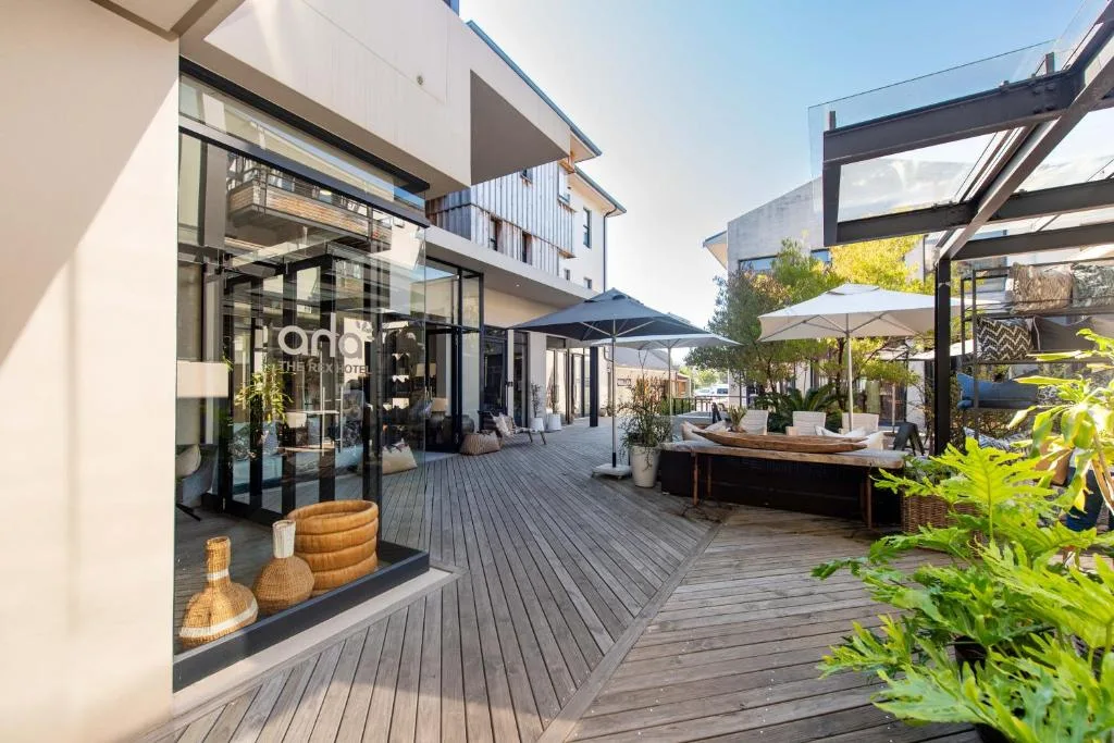 Modern wraparound deck with umbrellas, seating, and contemporary architecture