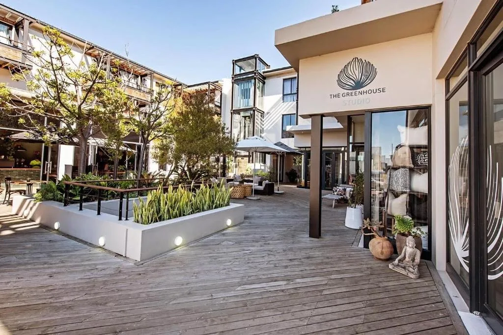 Spacious wooden deck with seating, planters, and storefront entrance