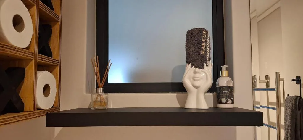 Decorative bathroom shelf with white head sculpture and amenities