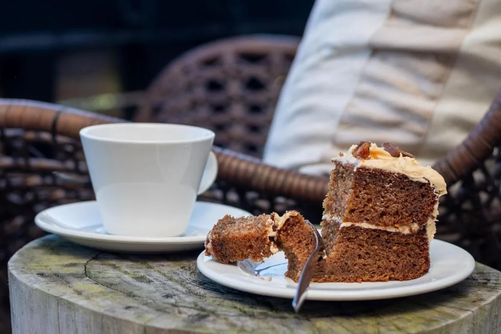 Coffee and homemade cake slice on rustic outdoor wooden table