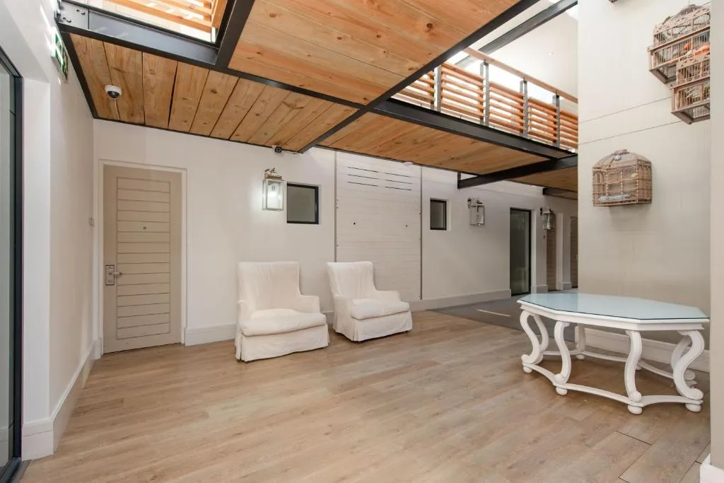 Spacious open-plan lounge with cream upholstered chairs and contemporary decor