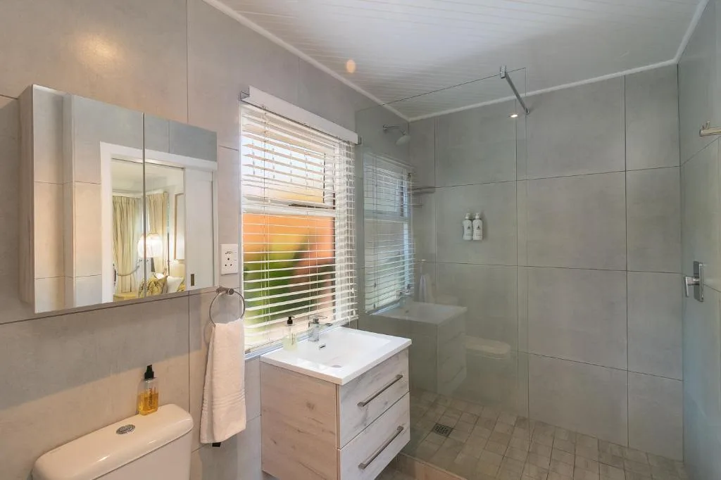 Modern bathroom with walk-in shower, vanity sink, and large mirror