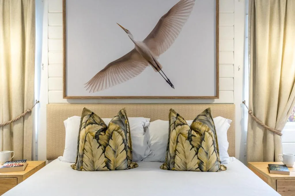 Bedroom with bed, decorative bird artwork, and patterned accent pillows