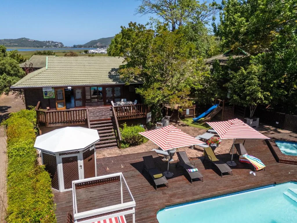 Wooden deck with loungers, umbrellas, and lagoon view beyond