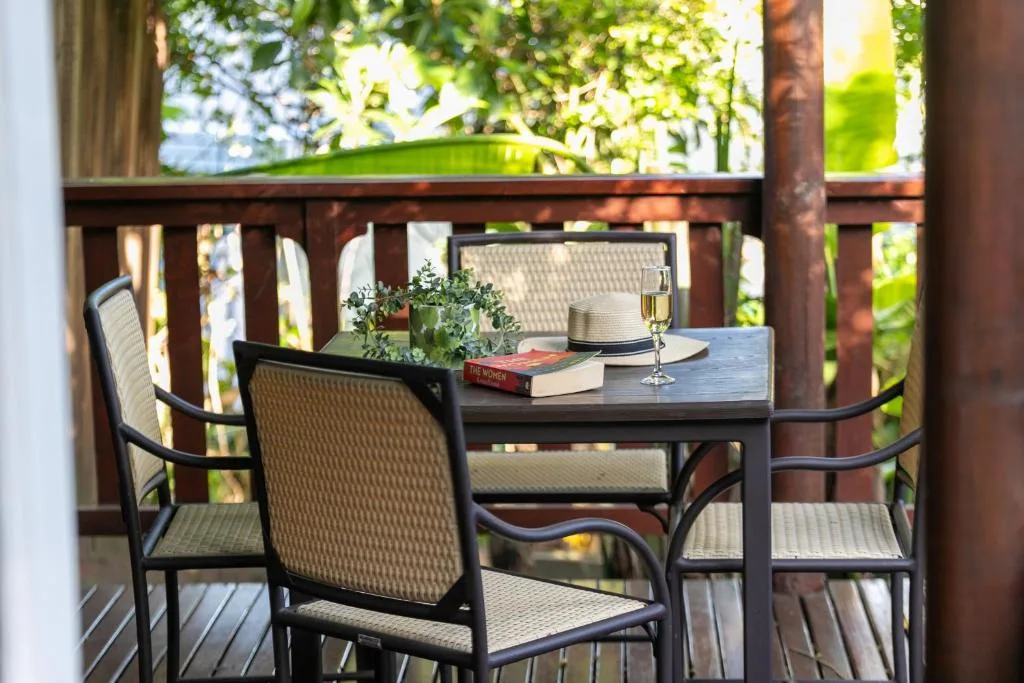 Shaded deck seating area with table, chairs, and garden views