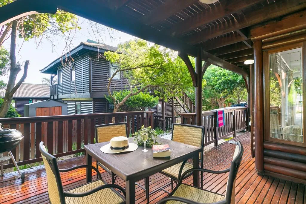 Spacious wooden deck with dining table and garden views of surrounding trees
