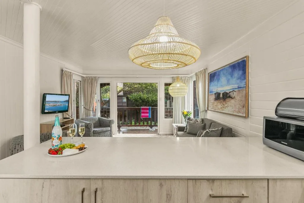 Modern kitchen with white countertop, stove, and open-plan lounge view