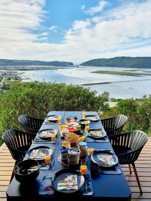 Outdoor dining table set with breakfast spread overlooking Knysna lagoon