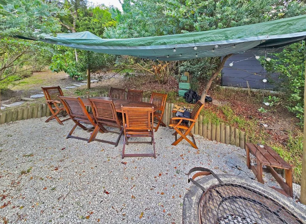 Shaded outdoor patio with wooden chairs and green canvas awning