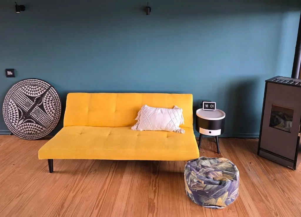 Modern lounge with yellow sofa, decorative cushion, and fireplace