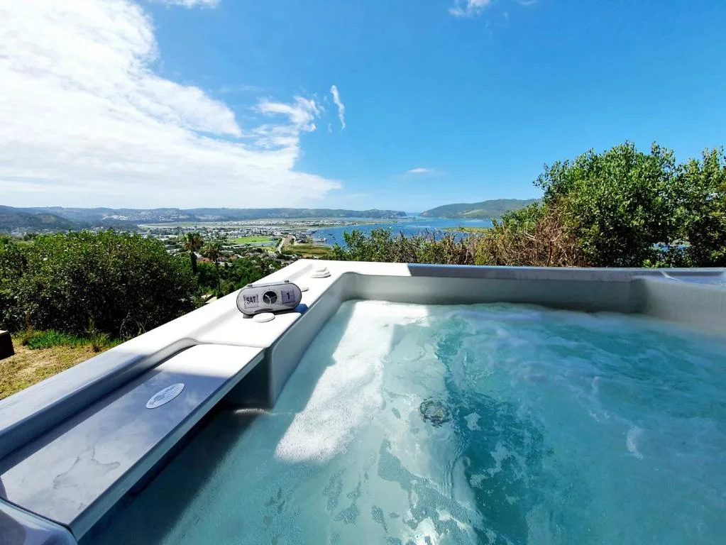 Outdoor jacuzzi with turquoise water overlooking Knysna Lagoon and mountains