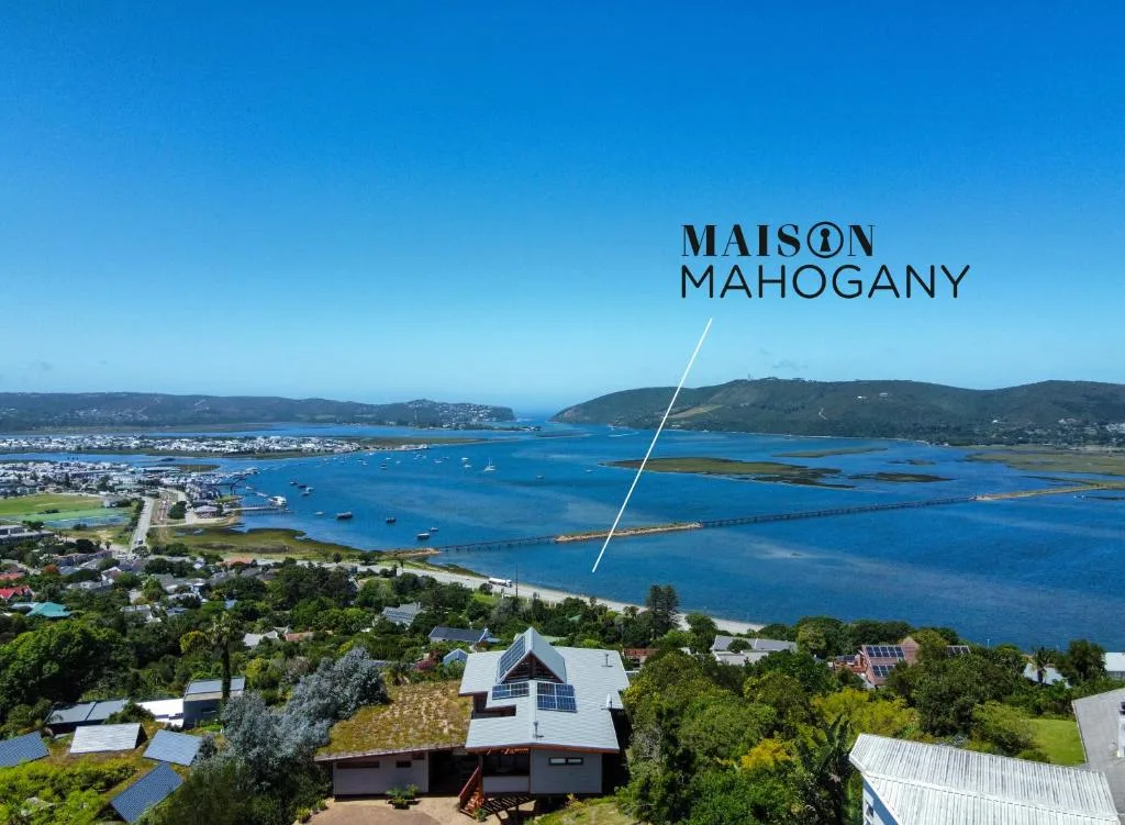 Stunning blue lagoon vista with boats and forested hills beyond