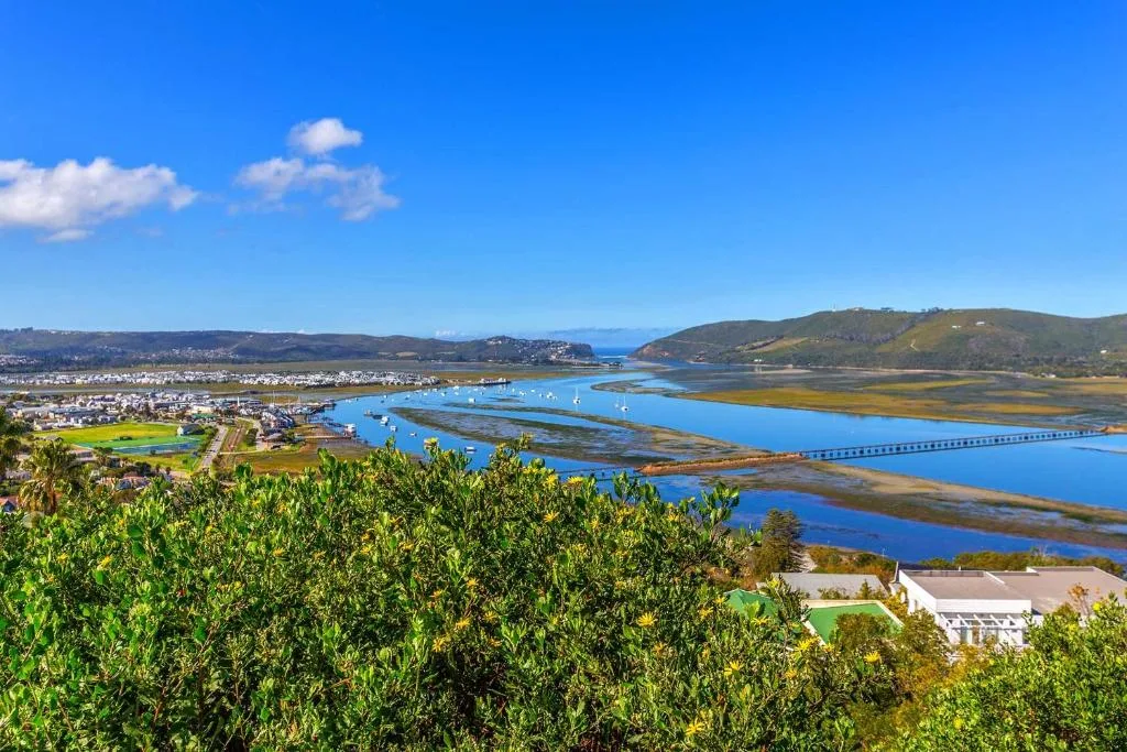 Scenic aerial view of Knysna lagoon with blue water, bridge, and surrounding hills
