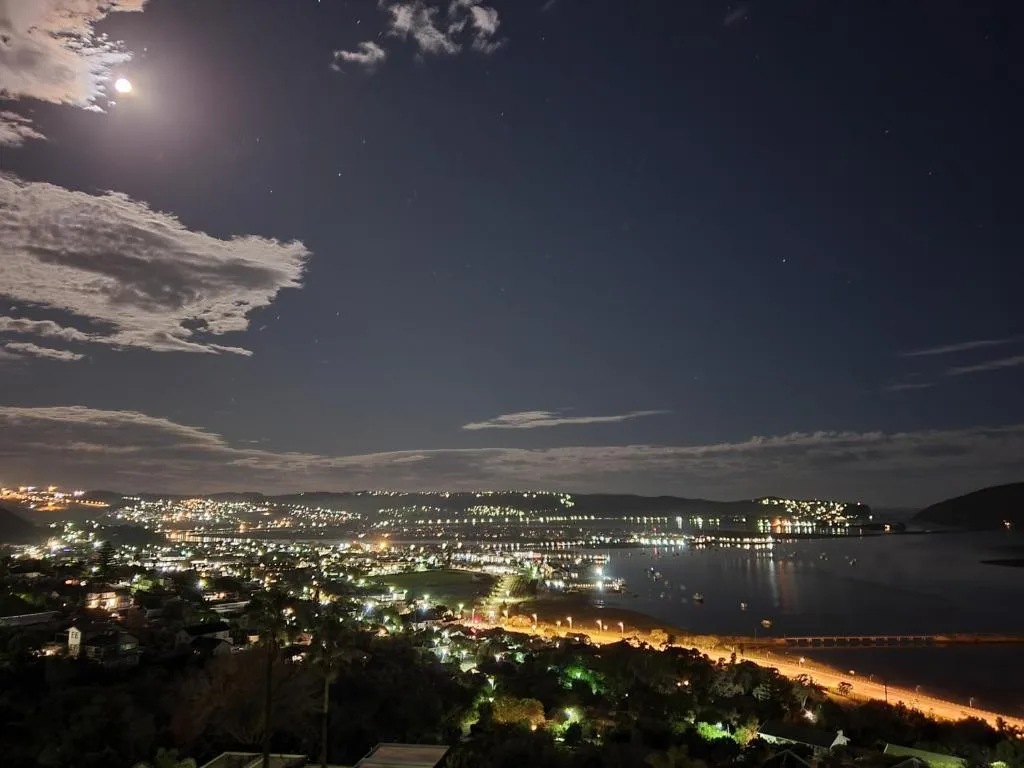 Moonlit lagoon and town lights reflecting on water at night