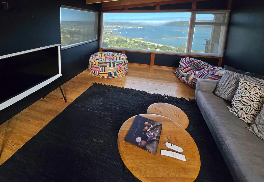 Lagoon vista framed by expansive windows from comfortable lounge space