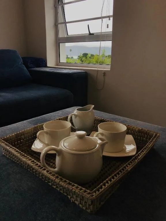 Living room with blue sofa, tea service, and views of green countryside beyond large window