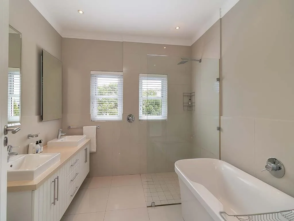 Modern bathroom with dual vanity, freestanding tub, and walk-in shower