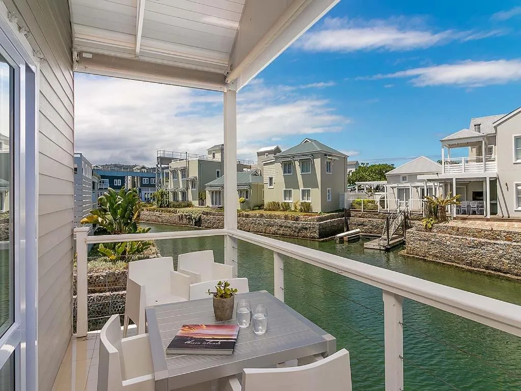 Waterfront deck with dining table overlooking canal and neighboring homes