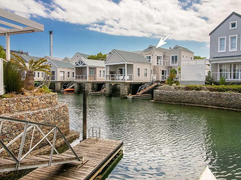 Waterfront holiday homes with wooden decks and stone foundations along calm canal