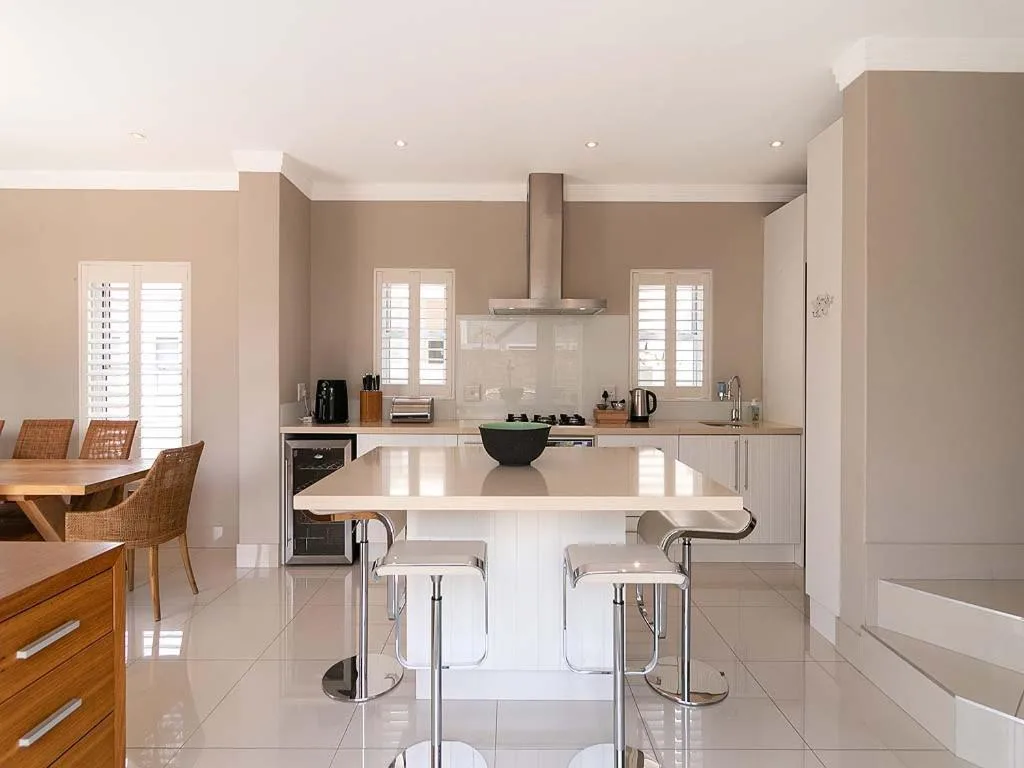 Modern kitchen with white island, stainless steel appliances and neutral cabinetry