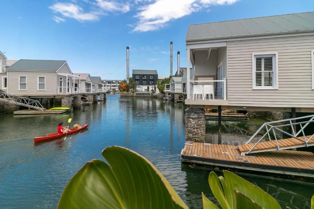 Waterfront holiday homes with kayaks on calm blue canal water