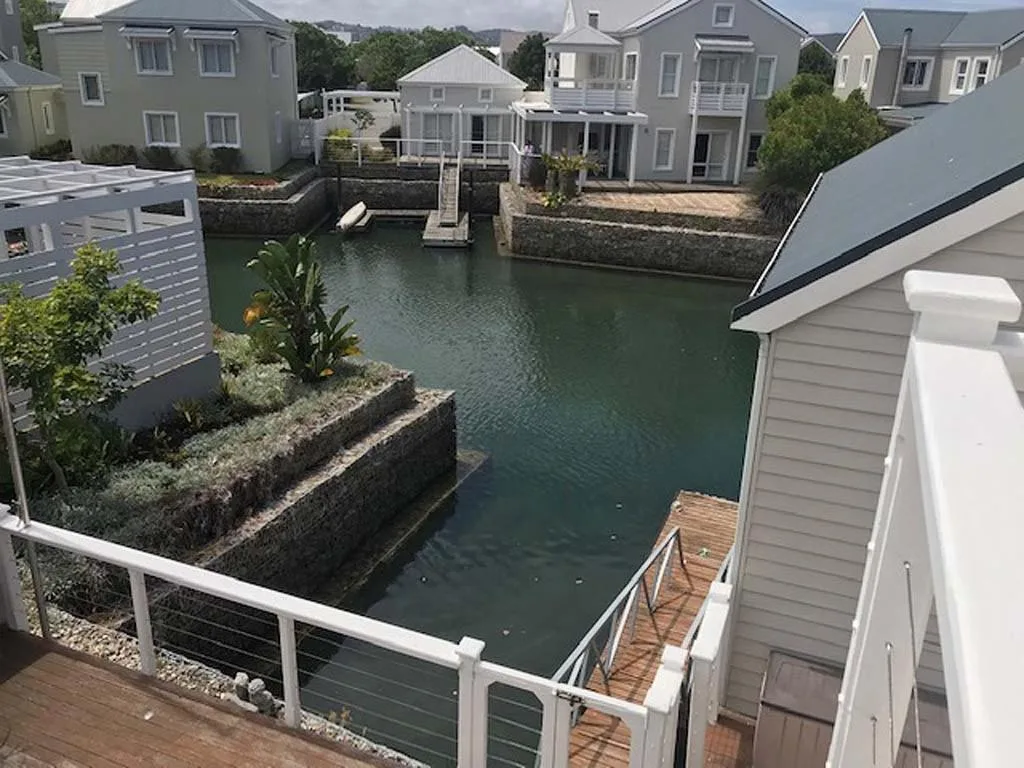 Scenic waterfront canal view with modern houses and lush landscaping