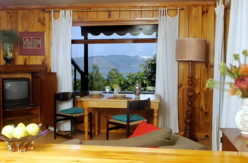 Wooden-paneled lounge with mountain and lagoon views through large windows