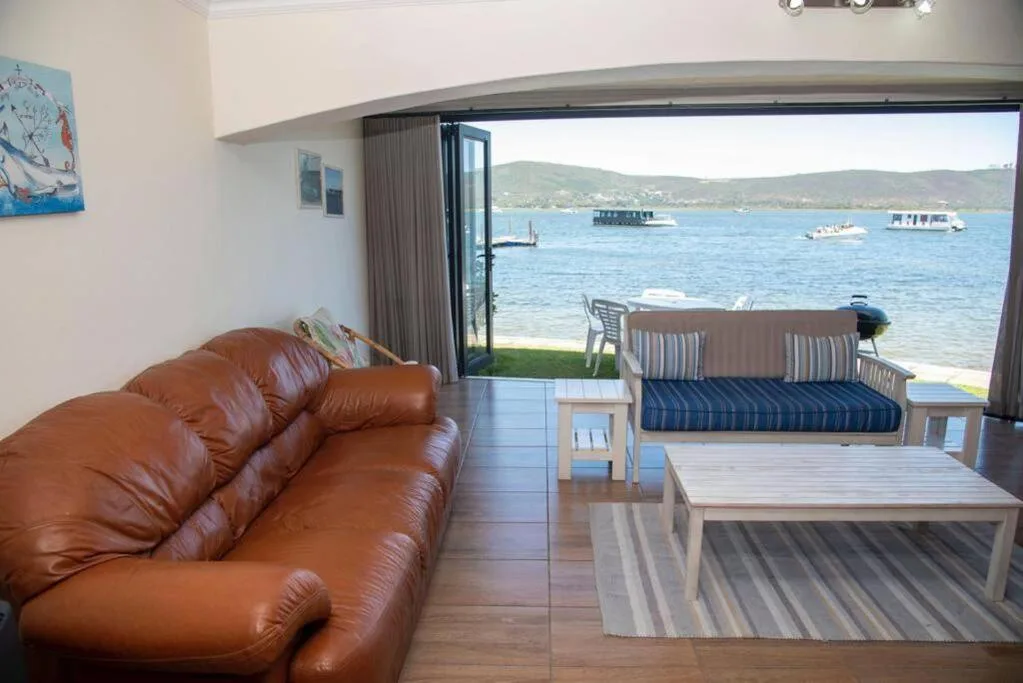 Spacious lounge with leather sofa overlooking Knysna lagoon and moored boats